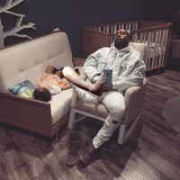 Kanye and North sleeping on display furniture at a nursery store.