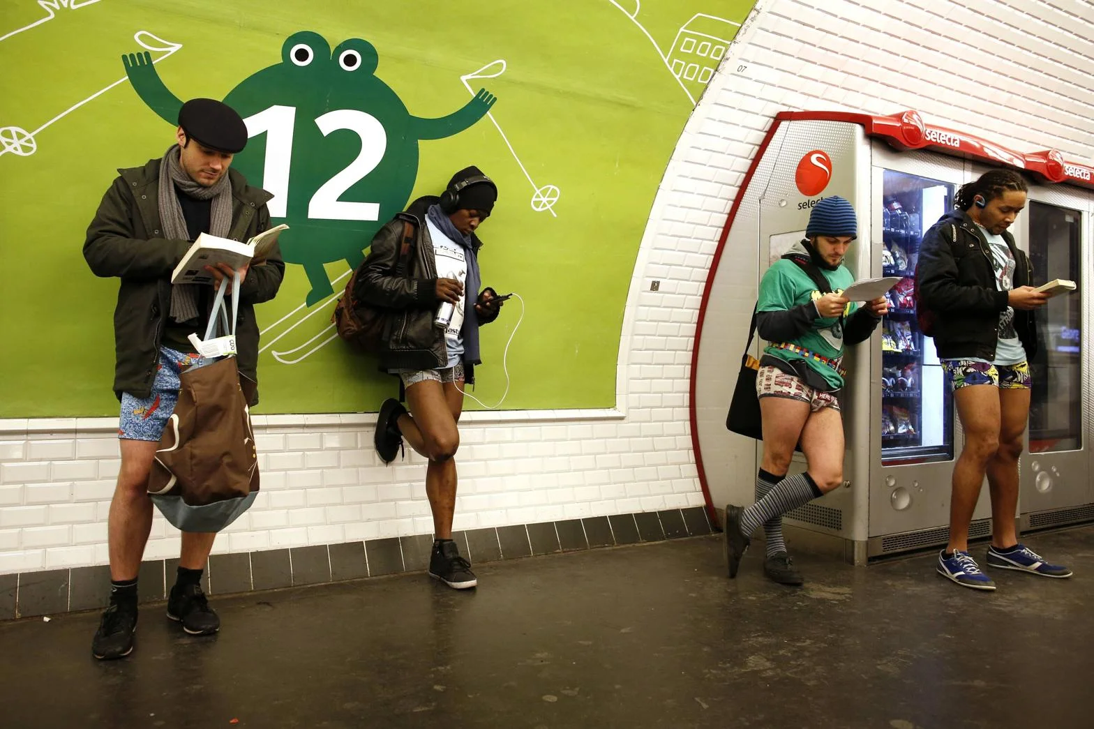 The No Pants Subway Ride goes international as participants nonchalantly wait at a Paris Metro station in nothing but jackets, underwear, and shoes.