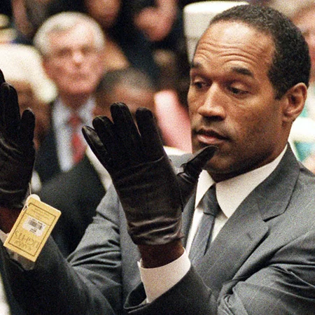 O.J. Simpson demonstrates the fit of the bloody leather gloves entered as evidence during his 1995 murder trial, a moment that inspired defense attorney Johnnie Cochran's famous line, 'If it doesn't fit, you must acquit.'