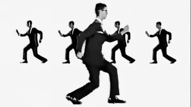 The iconic still from Talking Heads' 1980 'Once in a Lifetime' music video that became the visual foundation of the meme.