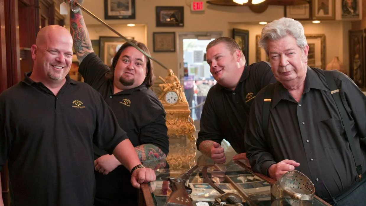 The Pawn Stars cast (Rick, Chumlee, Corey, and the Old Man) in the Gold & Silver Pawn Shop on the History Channel show.