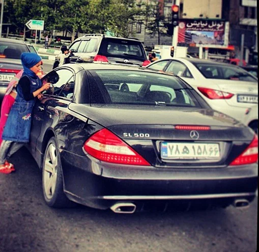 Street child meets expensive luxury car.