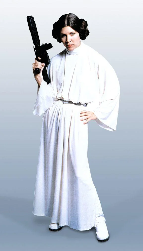 Classic promotional still of Princess Leia in her white gown wielding a blaster, from the original Star Wars.