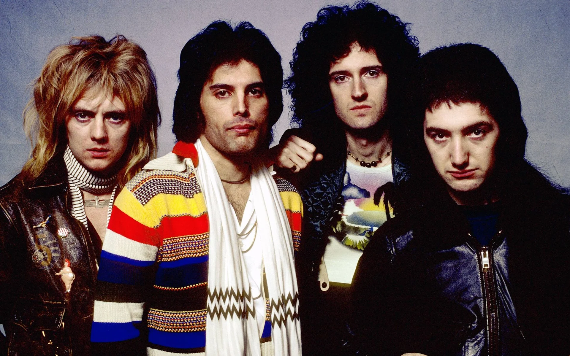 The four members of Queen — Roger Taylor, Freddie Mercury, Brian May, and John Deacon — in a classic promotional band portrait.