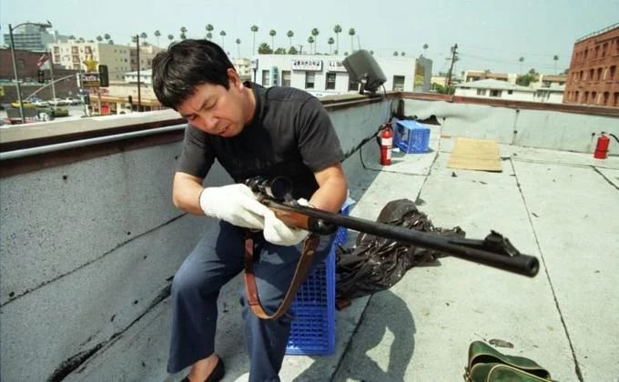 Canonical 1992 photograph of Roof Koreans rifle maintenance on rooftop.