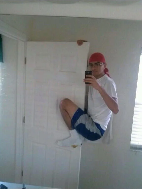 Person jumping mid-air in bathroom mirror.