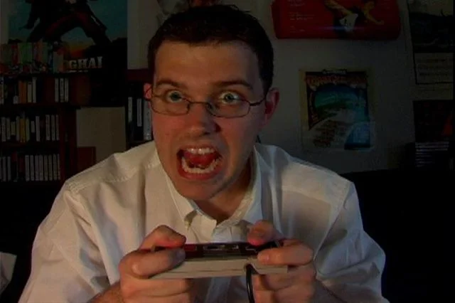 A screenshot of James Rolfe performing his signature furious reaction as the Angry Video Game Nerd (AVGN) while playing an NES game.
