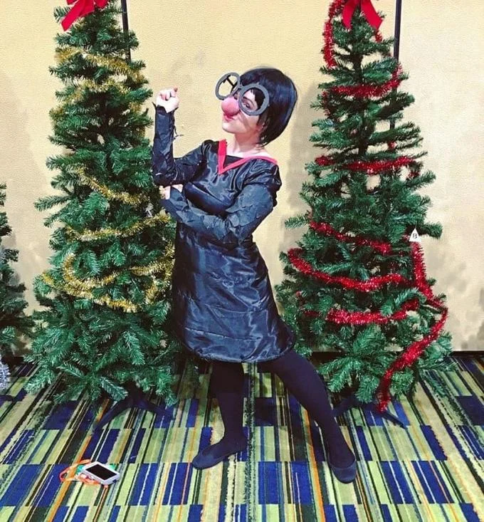 Low-budget cosplay rendition of Edna Mode from The Incredibles at a convention.