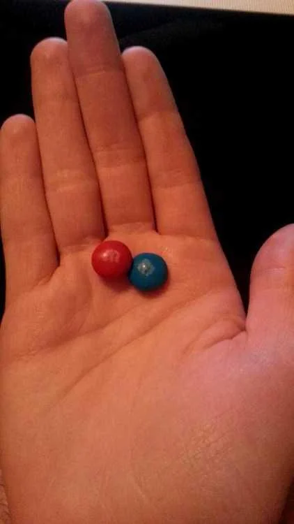 A playful real-life recreation of the red-pill/blue-pill choice using M&M candies.