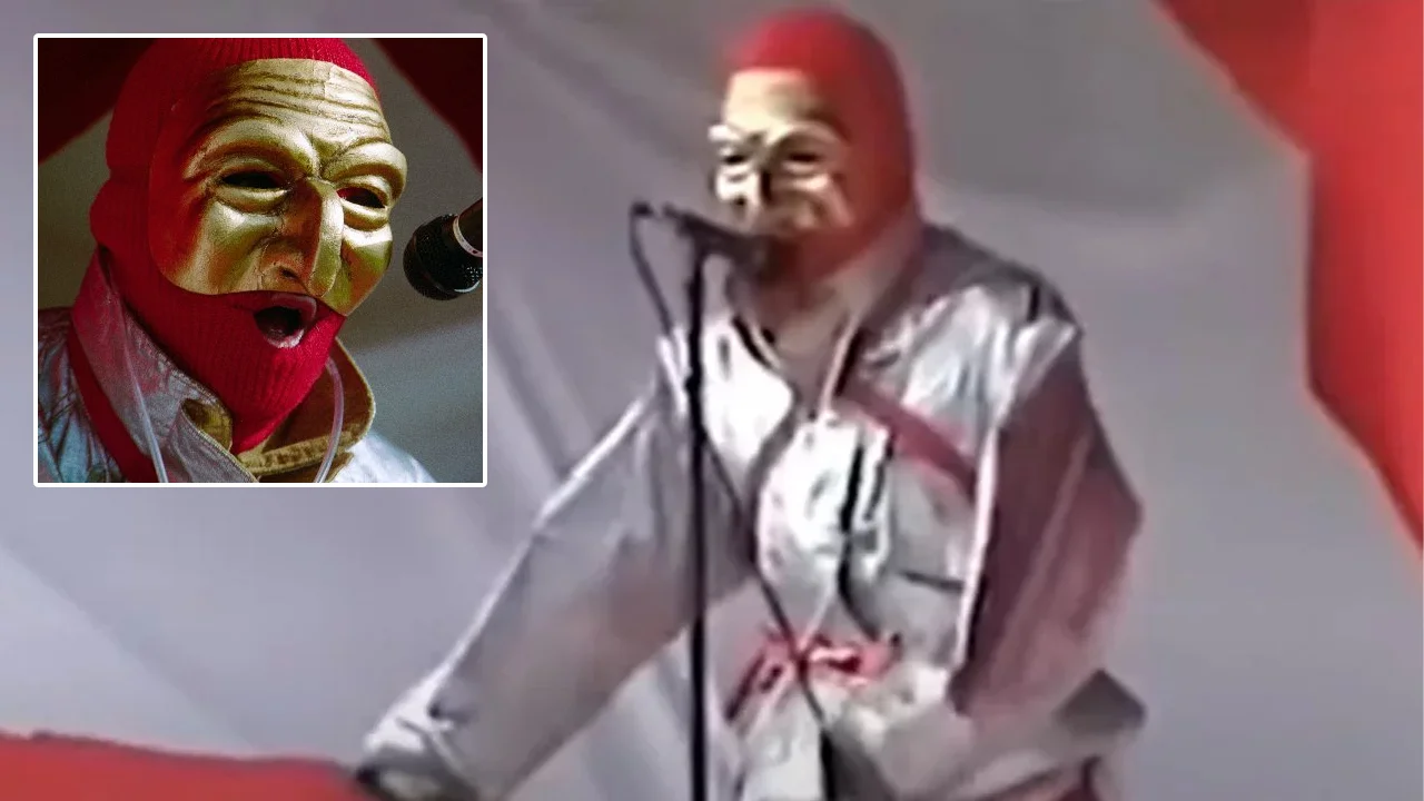 The PriceMaster performing live, wearing his signature gold mask, red balaclava, and silver jacket.