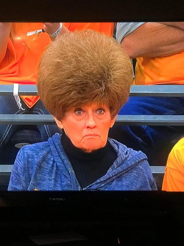 A TV capture of the viral Utah Jazz fan, highlighting the full-frame shot of her sky-high bouffant hairdo.
