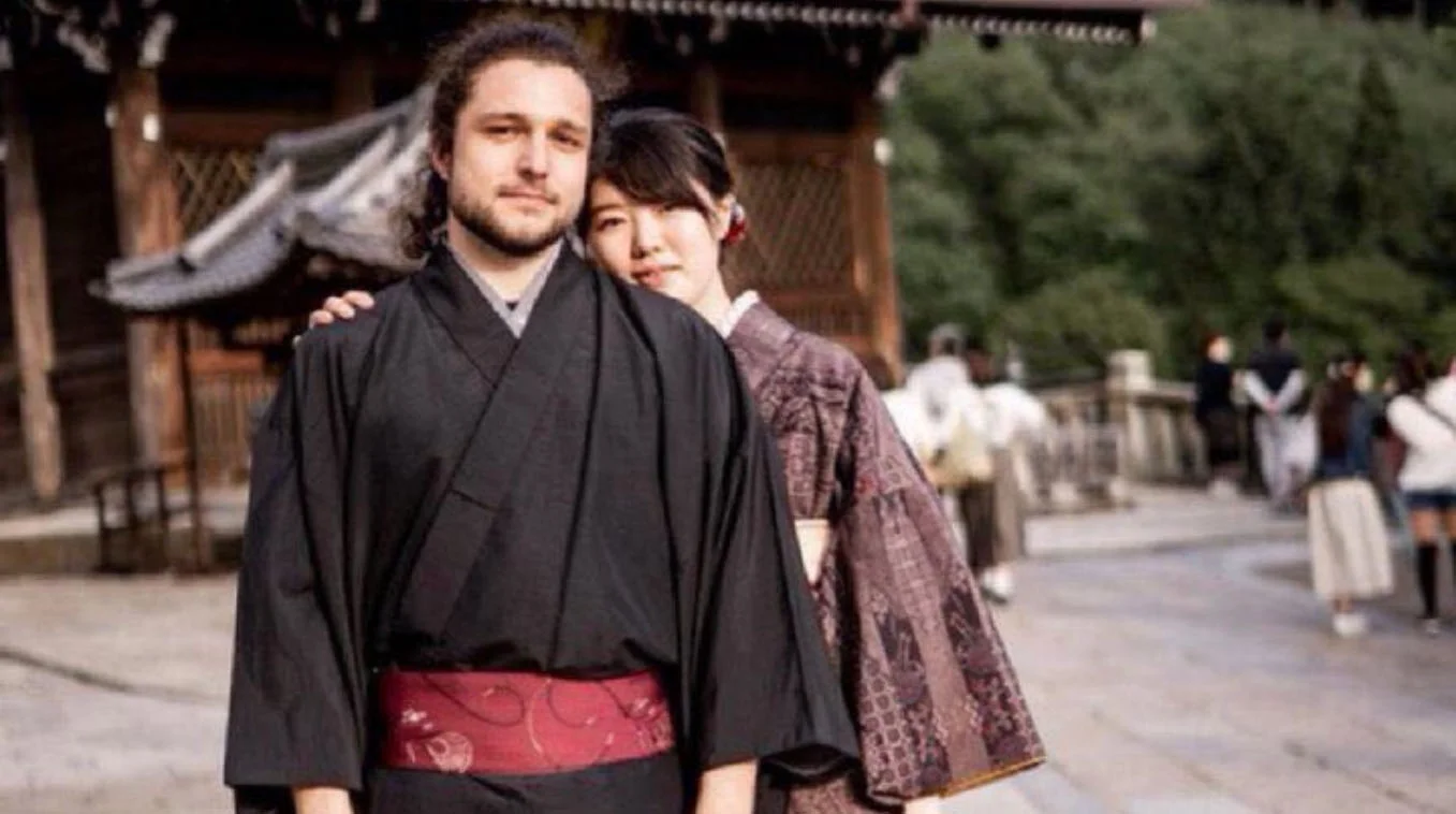 The source photograph that became the 'white man in a kimono' meme, showing the man and his Japanese partner outside a Japanese temple.